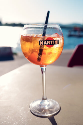 Uno spritz arancione ben freddo in un bicchiere su un tavolo soleggiato di Copa Beach.