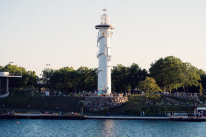 Il faro bianco di Copa Beach sulla sua base in pietra, circondato da alberi.