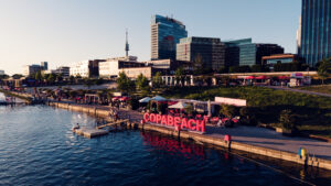 Veduta aerea delle lettere rosse COPABEACH sul molo, con Donau City sullo sfondo.