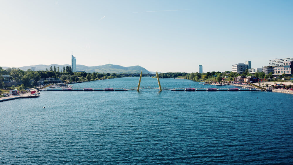 Il tranquillo Nuovo Danubio si estende verso le colline del Bosco Viennese, vicino al Ponte Cagrana.