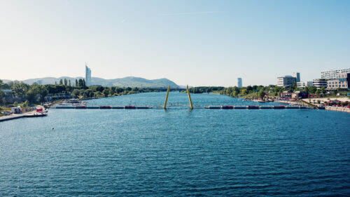 Il tranquillo Nuovo Danubio si estende verso le colline del Bosco Viennese, vicino al Ponte Cagrana.