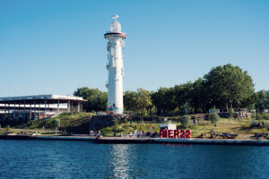 Il faro bianco accanto all'insegna del Pier 22, sulla riva di Copa Beach.