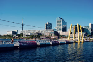 Il Donauturm e i piloni gialli del Ponte Cagrana, visti da Copa Beach dall'altra parte del Nuovo Danubio.
