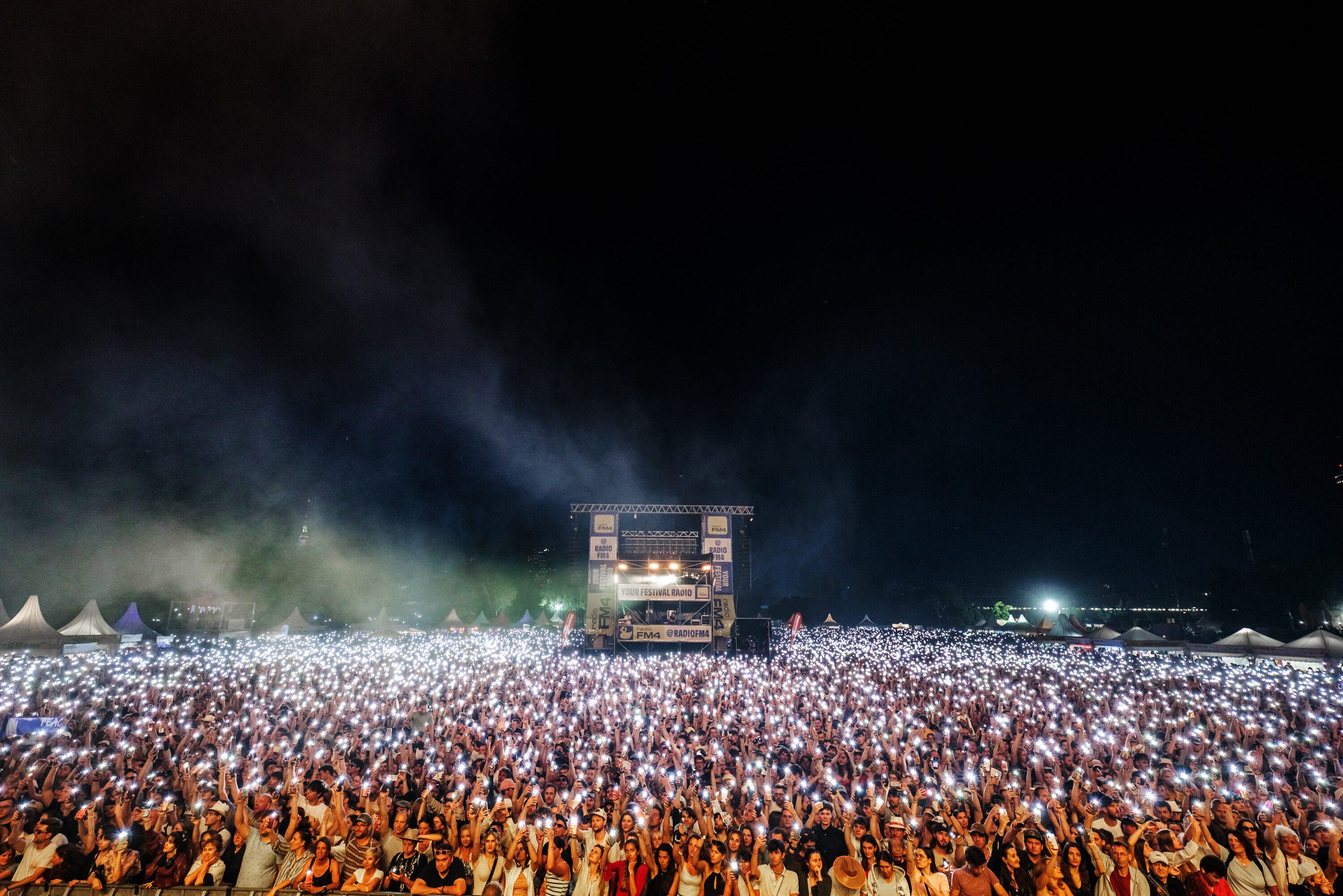 Thousands of festival-goers holding up phone lights in front of the FM4 stage at Donauinselfest at night © Donauinselfest / Alexander Müller