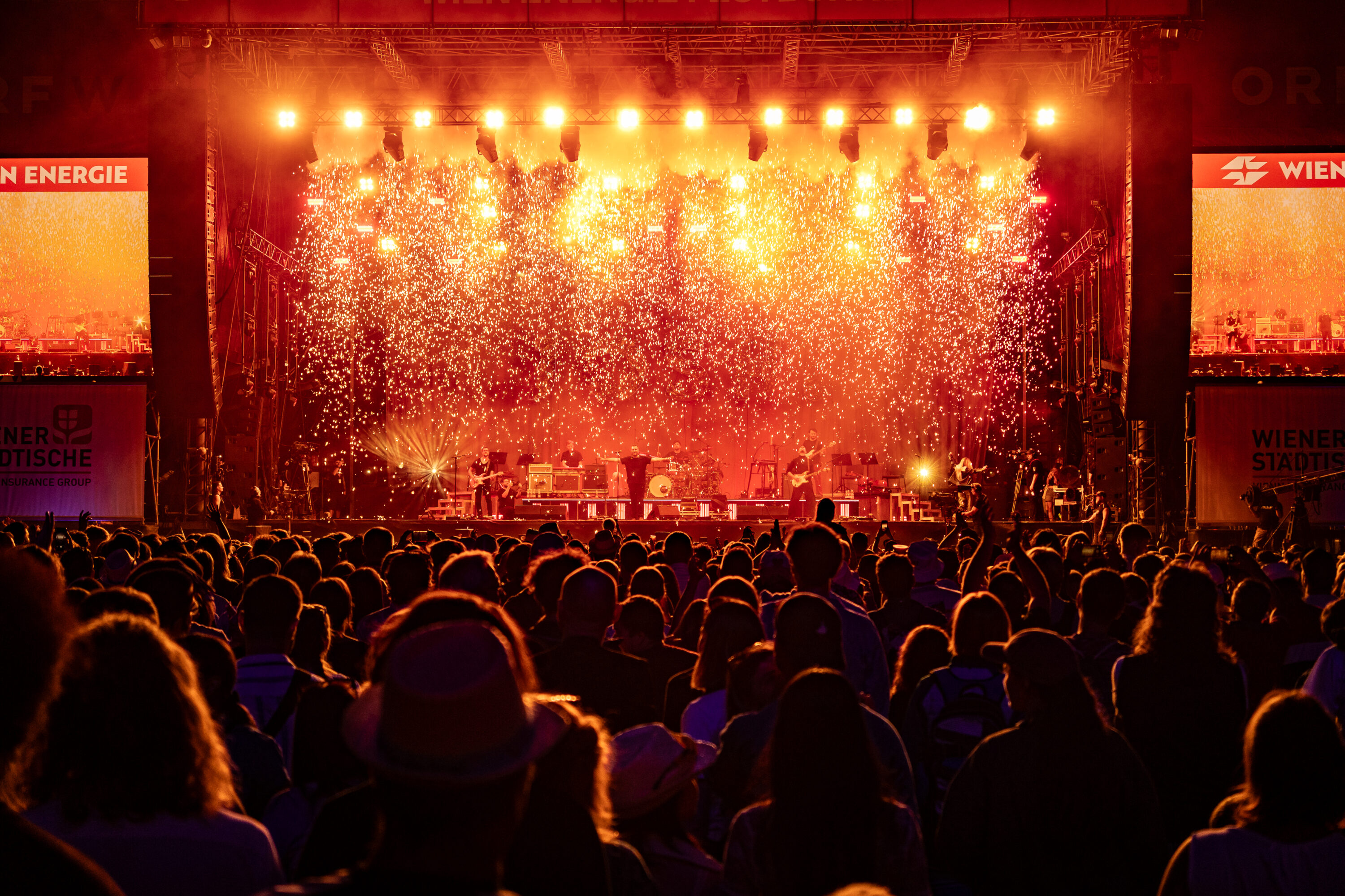 Band performing on the Wien Energie main stage at Donauinselfest with sparkler pyrotechnics and a crowd in silhouette © Donauinselfest / Matthias Lechner